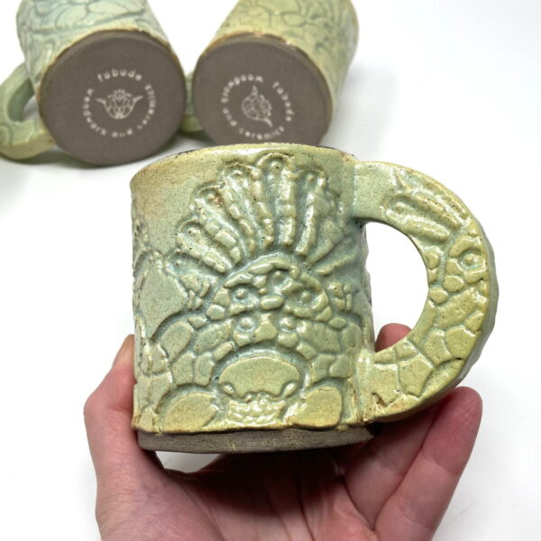 Handmade textured green ceramic pottery mug with handle