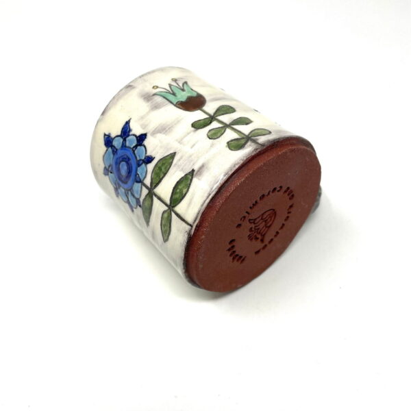 Handmade ceramic pottery mug with floral motives and handle with a metallic shine