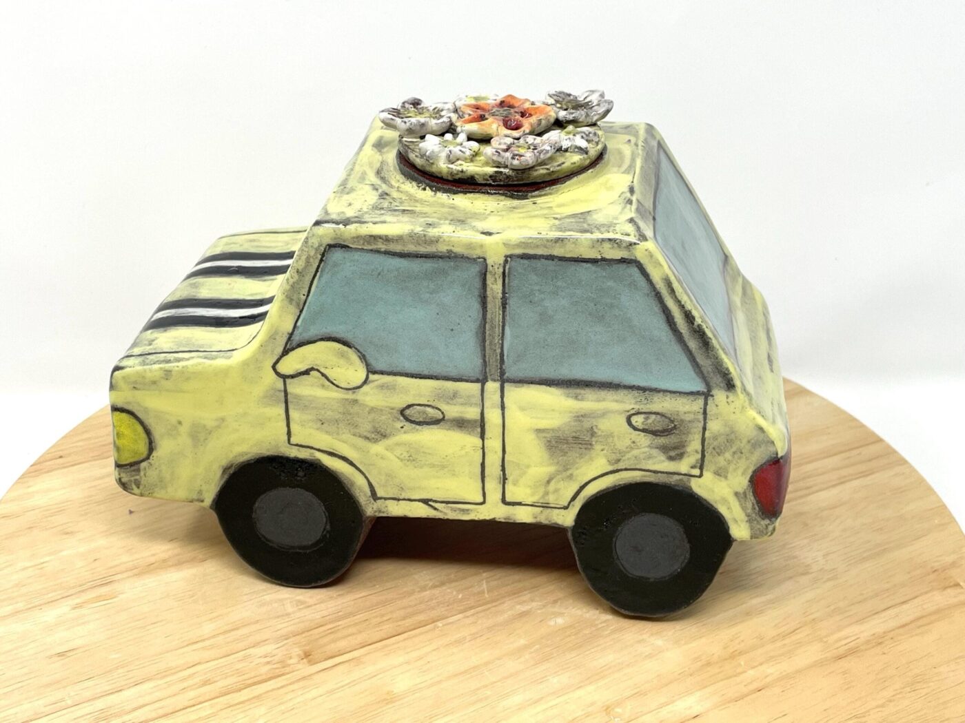 Pale Yellow Ceramic Car Vase with Floral Roof — in use
