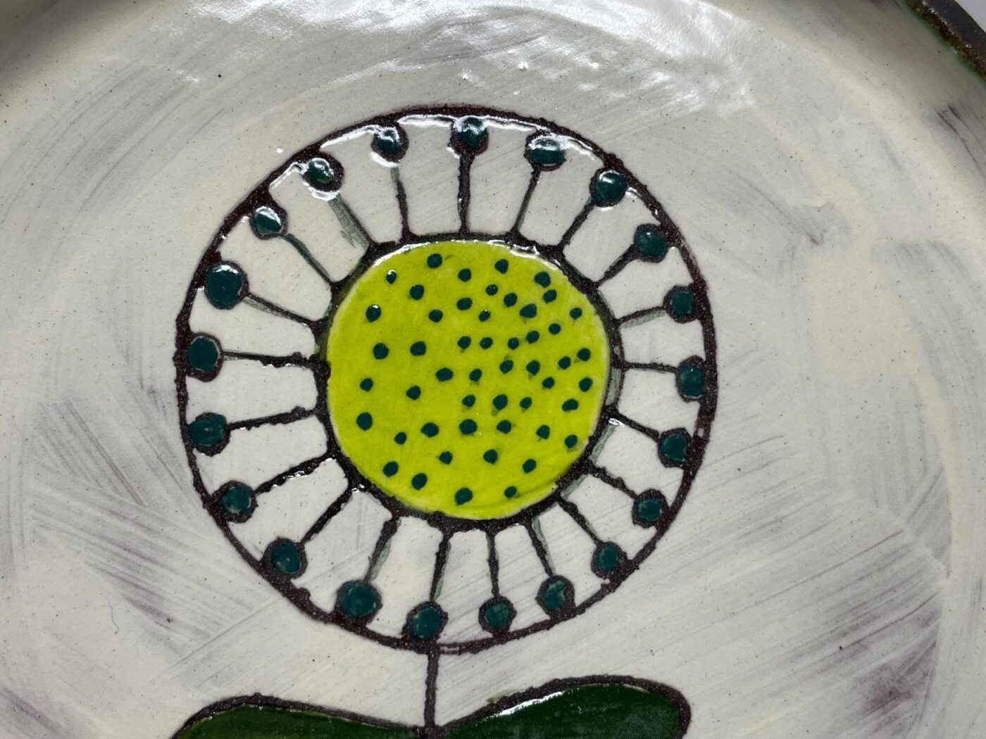 Side view of handmade ceramic sunflower plate — graphite rim — Fabode Ceramics