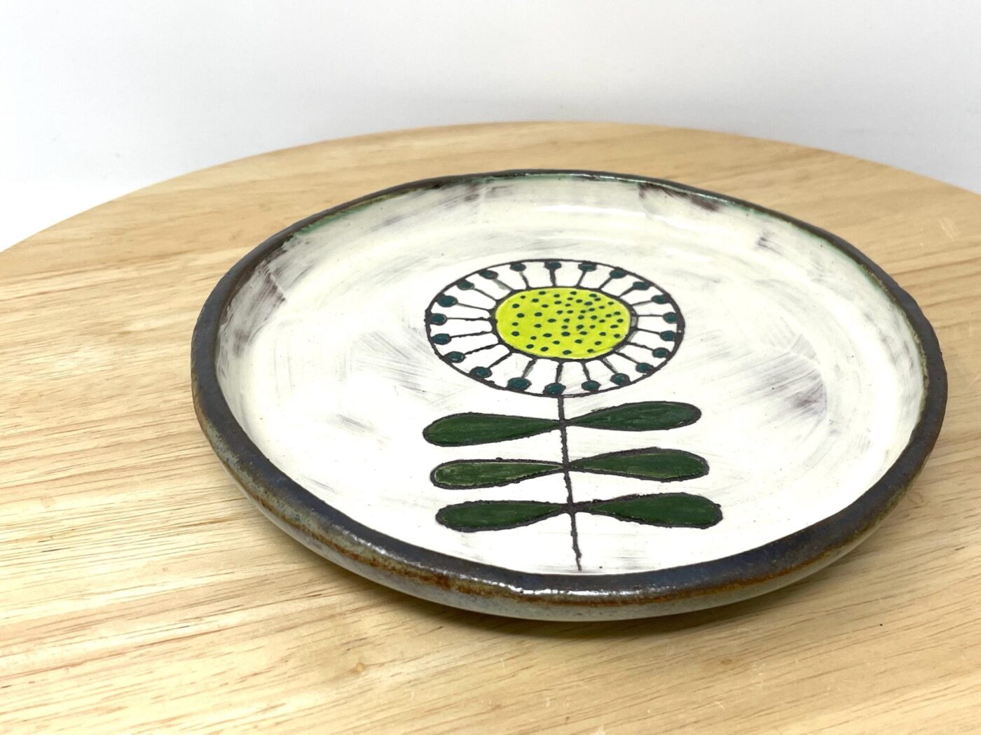 Ivory interior of handmade folk art sunflower plate — white slip glaze — Fabode Ceramics