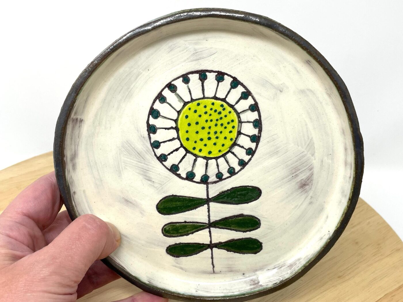 Sunflower ceramic plate detail — hand-scratched folk art design — Fabode Ceramics