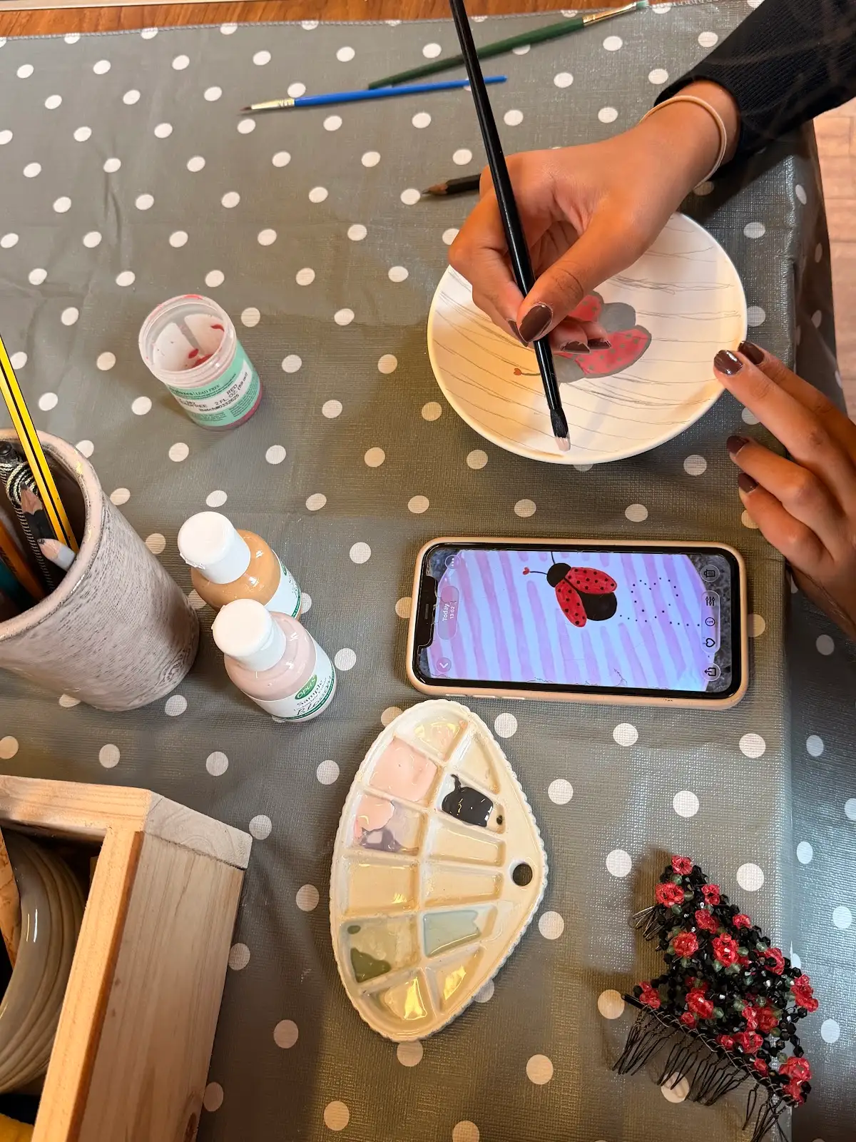 Participant painting a plate during a Paint Your Own Pottery session at Fabode