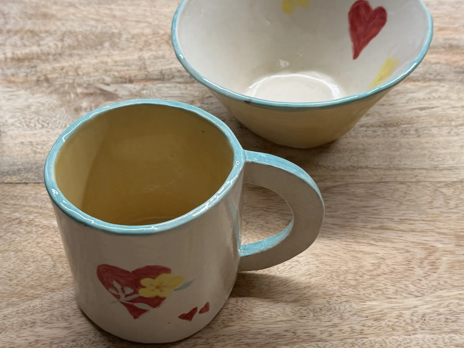White mug and bowl decorated with red hearts and yellow flowers at Fabode