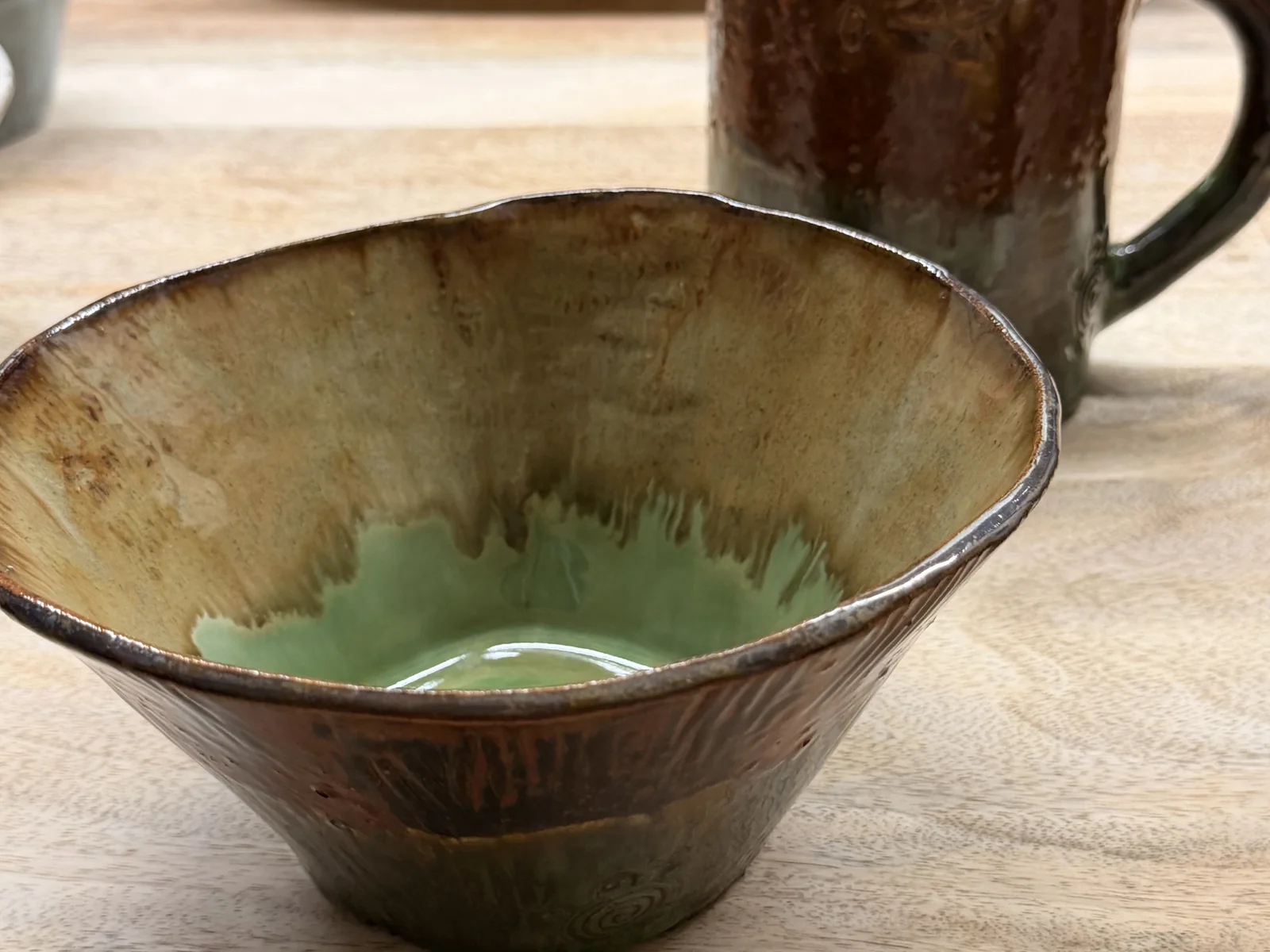 Earthy brown bowl and mug with a green glazed interior