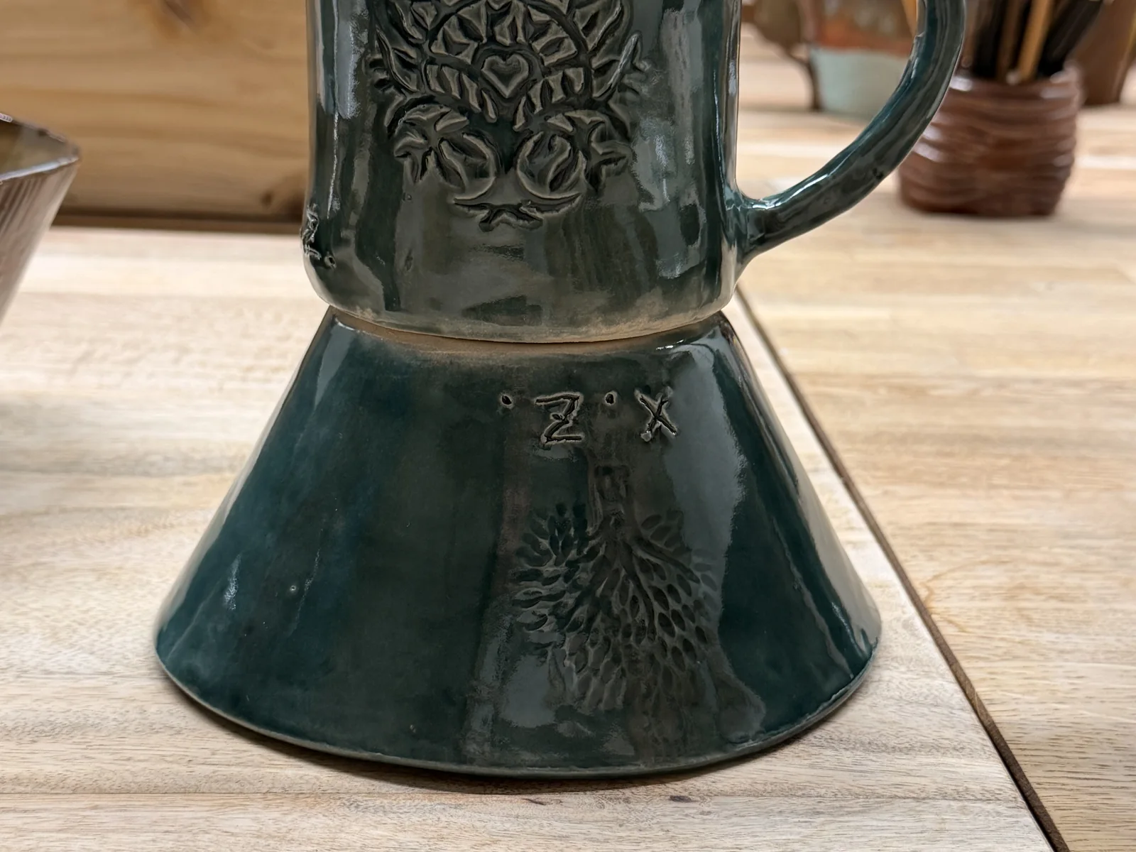 Deep green mug and bowl with stamped tree designs after firing