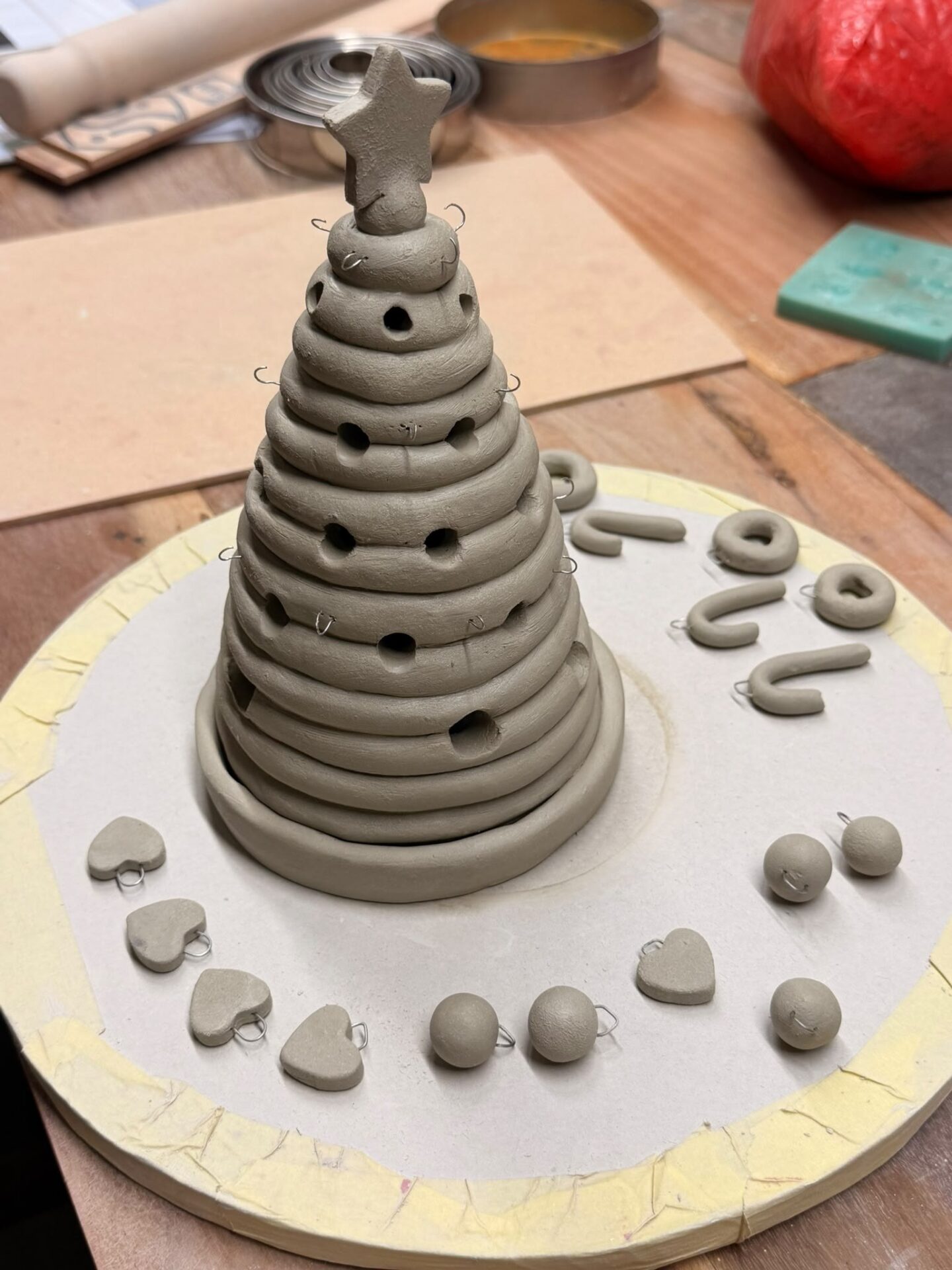 Unfired clay Christmas tree with a star topper and handmade miniature ornaments