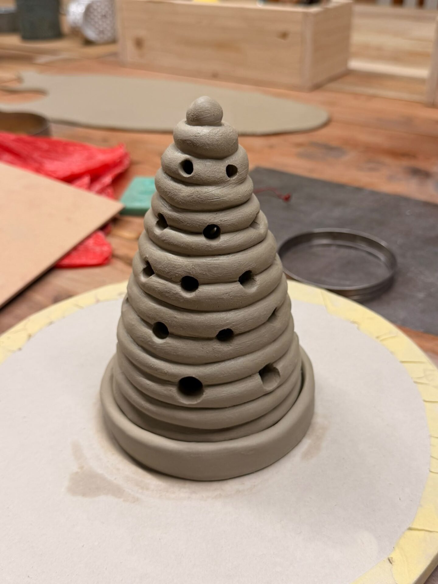 Coiled clay Christmas tree with openings for tealight illumination before firing