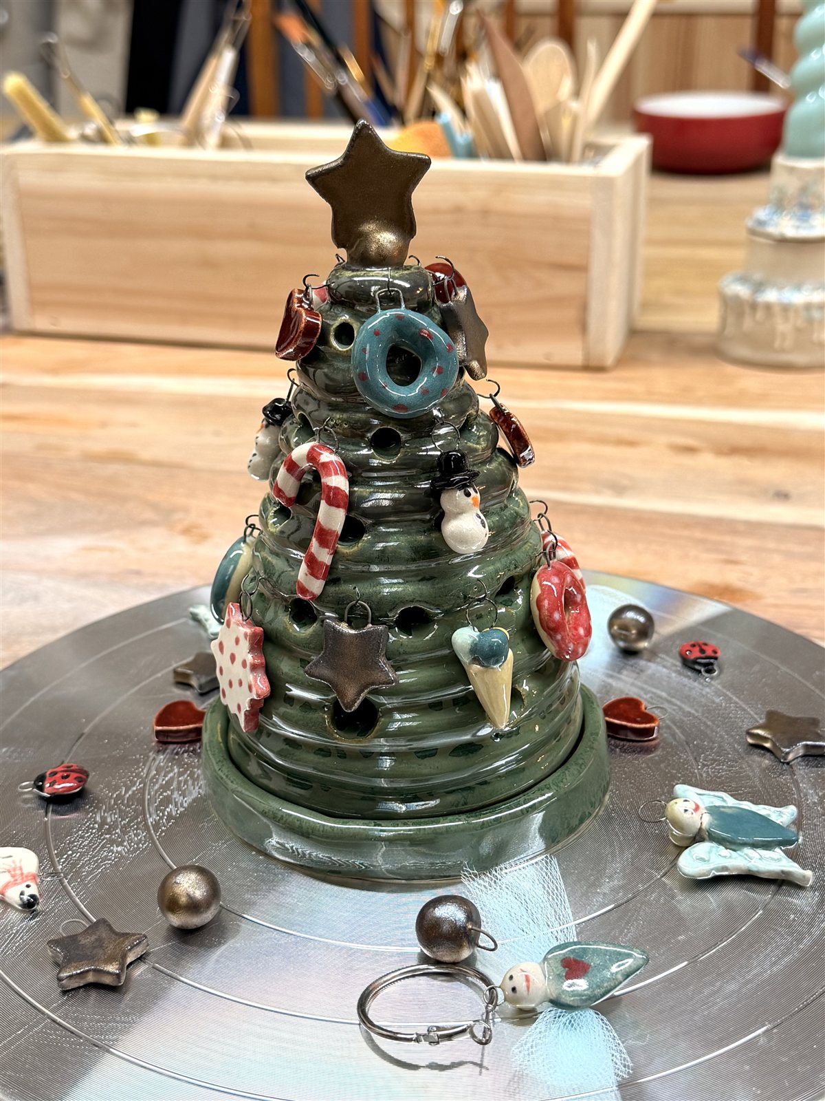 Finished green ceramic Christmas tree with miniature ornaments in the Fabode studio